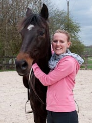 Pferd mit Reiter auf dem Reitplatz